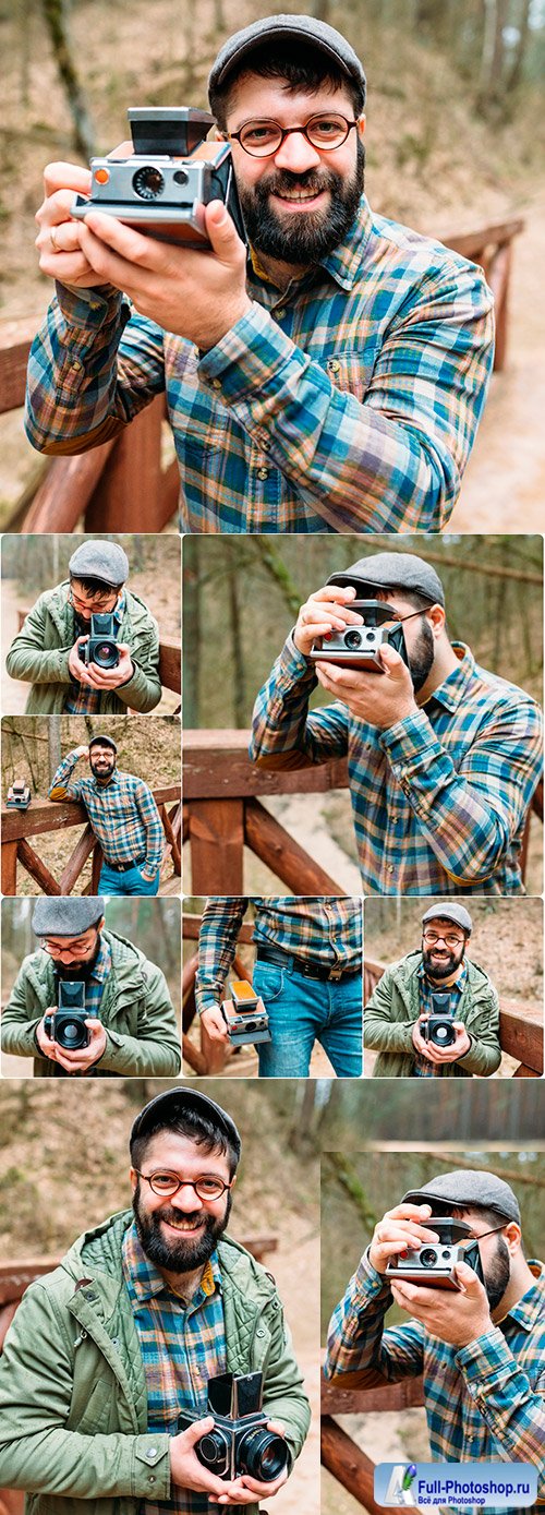 Young man with beard photographs movie in wood